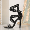 Single black caged stiletto sandal shown in side profile