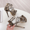 Leopard studded cage heels held for close product view