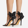 Black oversized bow stiletto sandals worn from rear angle
